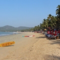 Sandy beach along the picturesque coast of Goa, with turquoise waves gently meeting the shore under a clear blue sky