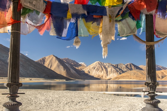 Breathtaking landscape of Leh Ladakh with rugged mountains, clear blue skies, and Buddhist monasteries.