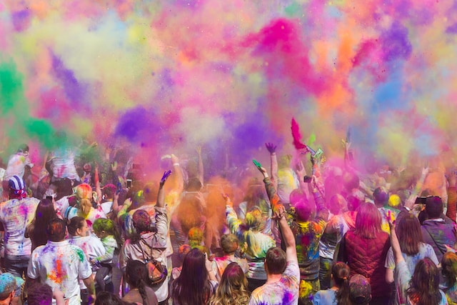 A lively Holi scene showing people throwing colorful powders and water, creating a festive atmosphere.