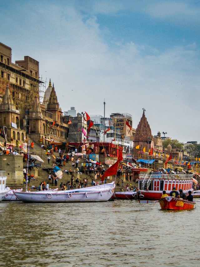 Spiritual scene by the Ganges River in Varanasi, India, with ghats, boats, and pilgrims