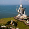 A captivating view of Murudeshwar, a coastal gem nestled in Karnataka, India. The iconic Shiva statue against the backdrop of the azure Arabian Sea and clear blue skies. Pristine beaches, ancient temples, and lush greenery make Murudeshwar a picturesque destination for travelers seeking serenity and cultural richness.