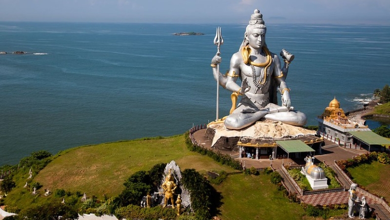 A captivating view of Murudeshwar, a coastal gem nestled in Karnataka, India. The iconic Shiva statue against the backdrop of the azure Arabian Sea and clear blue skies. Pristine beaches, ancient temples, and lush greenery make Murudeshwar a picturesque destination for travelers seeking serenity and cultural richness.