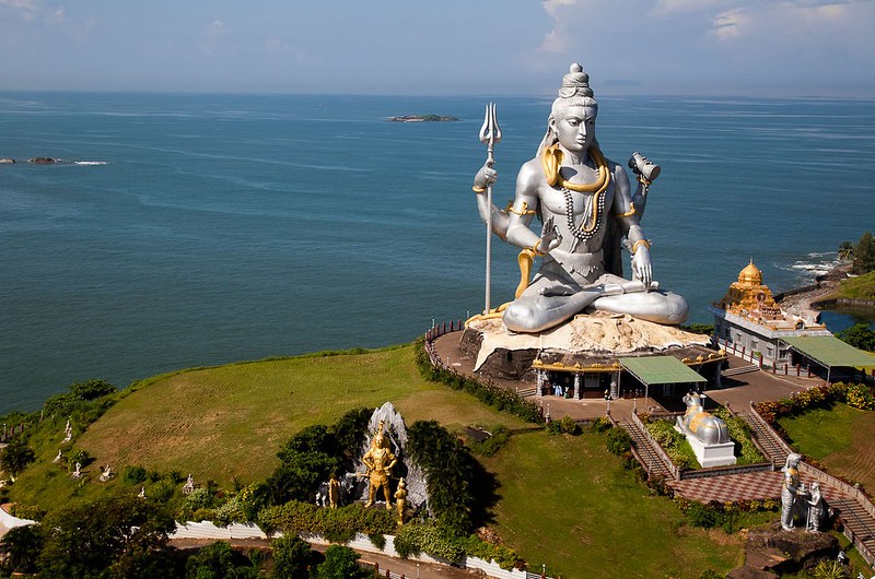 A captivating view of Murudeshwar, a coastal gem nestled in Karnataka, India. The iconic Shiva statue against the backdrop of the azure Arabian Sea and clear blue skies. Pristine beaches, ancient temples, and lush greenery make Murudeshwar a picturesque destination for travelers seeking serenity and cultural richness.