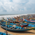 A travel guide titled 'Exploring the Charms of Puri: A Guide to Must-Visit Places' featuring a scenic view of Puri's coastline with clear blue skies, palm trees, and waves gently crashing on the shore.