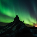 Travel destination: A panoramic view of the expansive Icelandic wilderness with towering mountains, serene lakes, and lush greenery, ideal for trekking adventures.