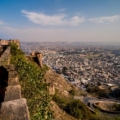 Aerial view of Nahargarh Fort nestled amidst lush greenery, overlooking the city of Jaipur. The fort's majestic walls and intricate architecture showcase Rajasthan's rich heritage and historical significance.