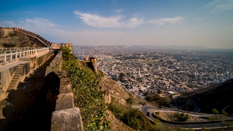 Aerial view of Nahargarh Fort nestled amidst lush greenery, overlooking the city of Jaipur. The fort's majestic walls and intricate architecture showcase Rajasthan's rich heritage and historical significance.