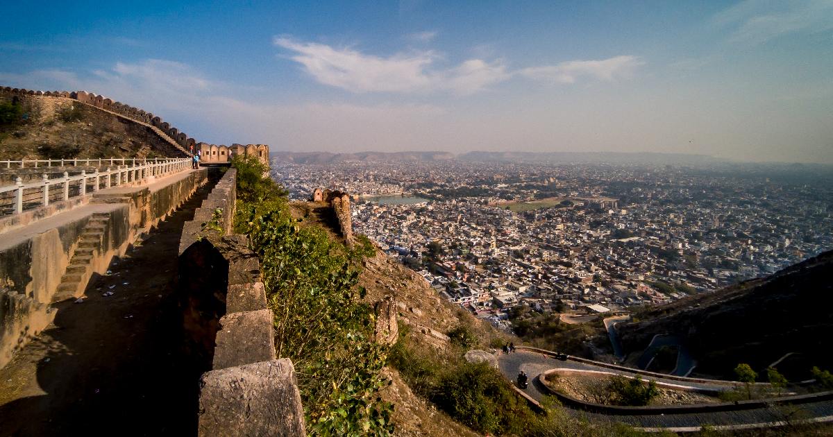 Aerial view of Nahargarh Fort nestled amidst lush greenery, overlooking the city of Jaipur. The fort's majestic walls and intricate architecture showcase Rajasthan's rich heritage and historical significance.